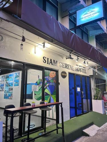 a building with a table and chairs in front of it at Siam Serene Hostel Khaosan in Bangkok