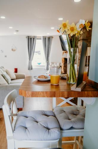 a living room with a table with a vase of flowers at Gwens House in Brynsiencyn