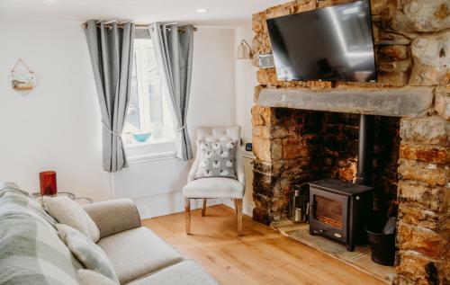 a living room with a fireplace with a tv on top at Gwens House in Brynsiencyn