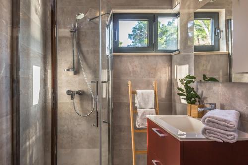 a bathroom with a shower and a sink at Villa REANA in Brela