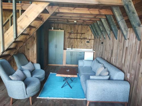 a living room with two blue chairs and a table at İtenicibungolow in Korgan
