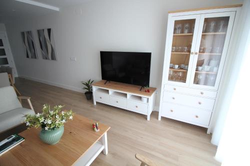 a living room with a television and a white cabinet at Atardecer en el Jerte in Cabezuela del Valle