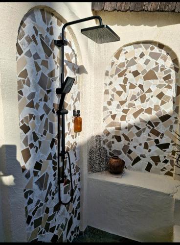 a shower in a bathroom with a stone wall at Gîte Les Galins in Lux