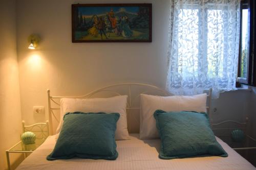 a bedroom with a bed with two pillows and a window at Villa Marko in Ljubitovica