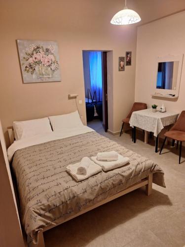 a bedroom with a bed with two towels on it at ILIANA apartments in Preveza