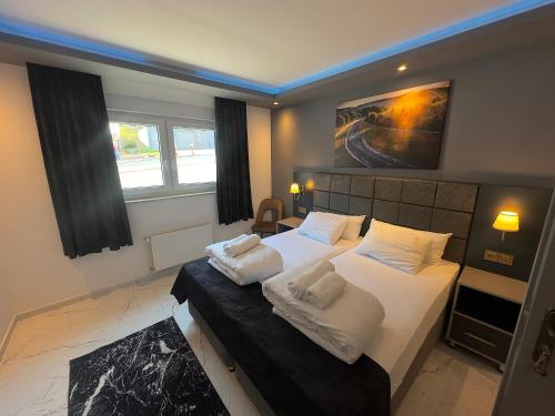 ein Schlafzimmer mit einem großen Bett mit weißen Laken und Kissen in der Unterkunft NRING VILLA Adenau in Adenau