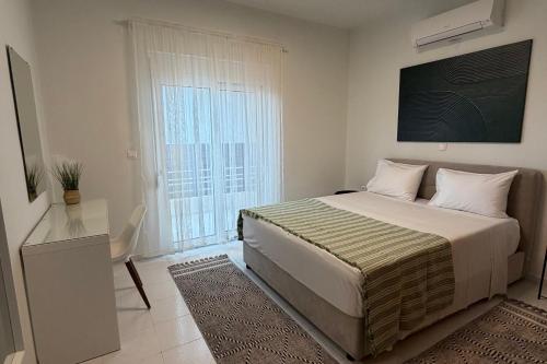 a bedroom with a bed and a large window at Villa Lonaki in Haraki