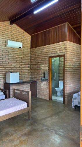 a room with a bed and a bathroom with a toilet at Estância da Mata in CÃ¡ssia