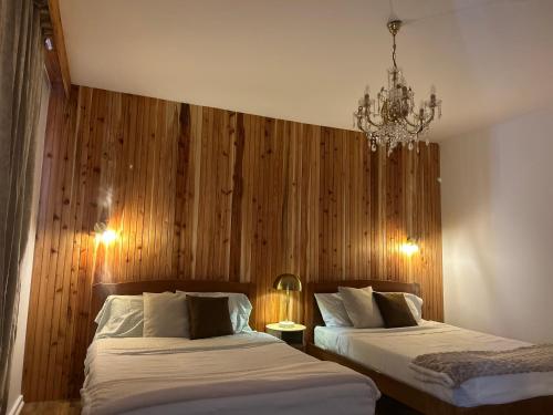 a bedroom with two beds and a chandelier at Central House in Ribeira Grande