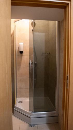 a shower with a glass door in a bathroom at Valmiera Park Hostel in Valmiera
