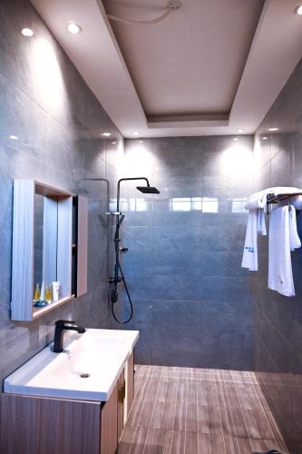 a bathroom with a shower and a sink and a shower at Neon Hotel in Kampala