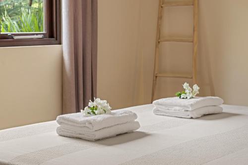 two towels sitting on top of a bed at Villa The Hidden Palm, Piscadera, Private Pool in Willemstad