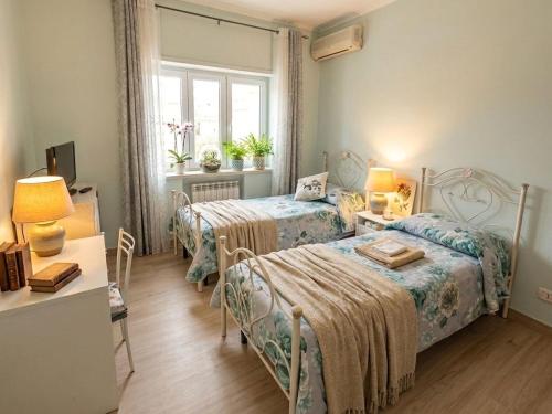 a bedroom with two beds and a table and a window at Casa Dolce Casa Napoli&Amalfi&Positano 6&7 Alloggiano gratis in Trecase
