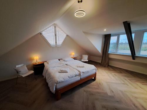 a bedroom with a large bed in a attic at Erve Lindehof in Lochem