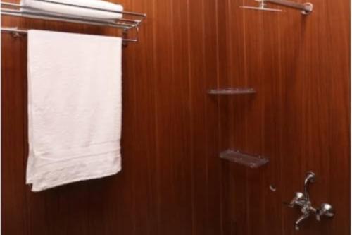 a bathroom with a towel hanging on a wooden wall at Hotel Meerut International in Meerut