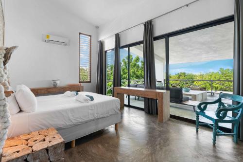 a bedroom with a bed and a chair and a balcony at Vista Alegre by Boutique Bonaire Unique Resorts in Kralendijk