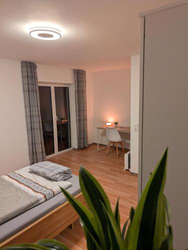 a bedroom with a bed and a table in a room at Google Smart Home Unterkunft - 1 in Kenn