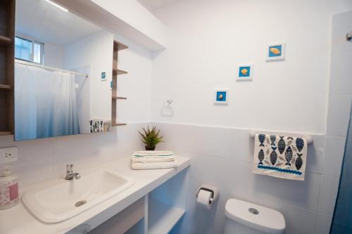 ein weißes Badezimmer mit Waschbecken und Toilette in der Unterkunft Flamingo Beach Santa Marianita Manta in Manta