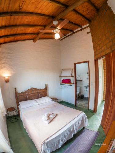 a bedroom with a bed and a wooden ceiling at Sítio Embaú in Carrancas