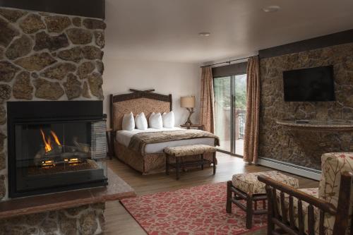 um quarto de hotel com uma cama e uma lareira em The Landing at Estes Park em Estes Park