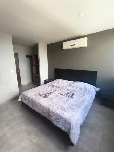 a bedroom with a bed with a blanket on it at Buyan Departamentos in Mérida