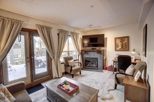 a living room with a fireplace and a couch at Fire Mountain 204 2 Level, 2 bed, great views! in Canmore