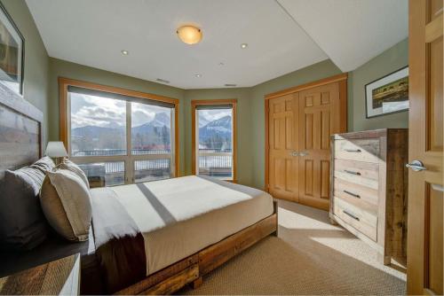 a bedroom with a bed and a large window at 212 Alpine Village Spacious 2Bed-2Bath-Mtn Views! in Canmore