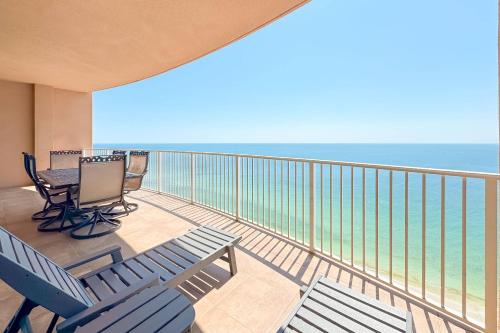 a balcony with two blue chairs and the ocean at Phoenix Gulf Shores 2102 in Gulf Shores