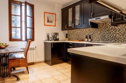 a kitchen with black cabinets and a table and a counter at Casa con jardìn en Son Españolet in Palma de Mallorca