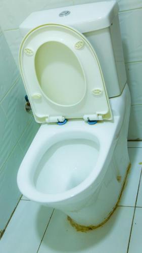 a white toilet with the seat up in a bathroom at KiGALI CITY COMFORT ACCOMMODATION in Kigali