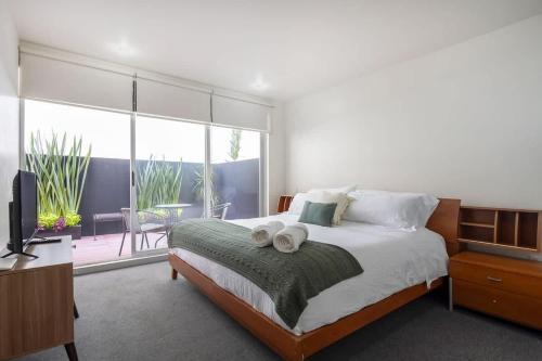 a bedroom with a bed with towels on it at Chic 2BR Condo in Condesa steps from Parque Mexico in Mexico City