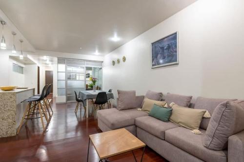 a living room with a couch and a table and a kitchen at Chic 2BR Condo in Condesa steps from Parque Mexico in Mexico City