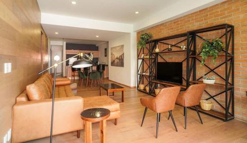 a living room with a couch and a brick wall at Luxury 3BR Pool and Gym in Roma in Mexico City