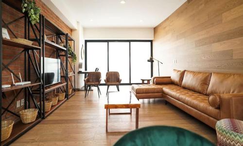 a living room with a leather couch and a table at Luxury 3BR Pool and Gym in Roma in Mexico City
