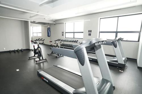 a gym with treadmills and machines in a room at Luxury 3BR Pool and Gym in Roma in Mexico City