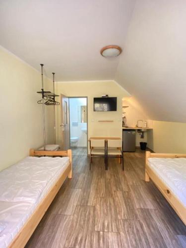 a room with two beds and a table in it at Agrowinnica in Borzytuchom