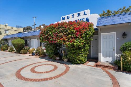 a motel sign on the side of a building with flowers at Rest Haven Motel in Los Angeles