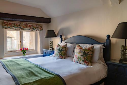 a bedroom with a large bed and a window at The Wensleydale Hotel in Middleham