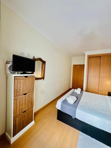 a small bedroom with a bed and a tv at Renaissance sunrises inn in Portimão