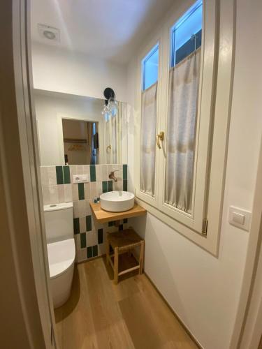 a bathroom with a sink and a toilet and a window at Hotelet Bastio 12 in Ciutadella