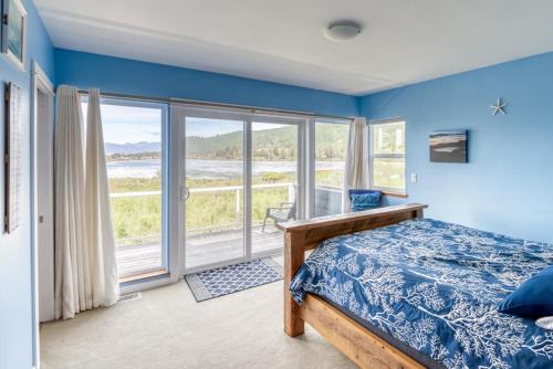 a bedroom with a bed and a large window at Lakeside Haven in Rockaway Beach