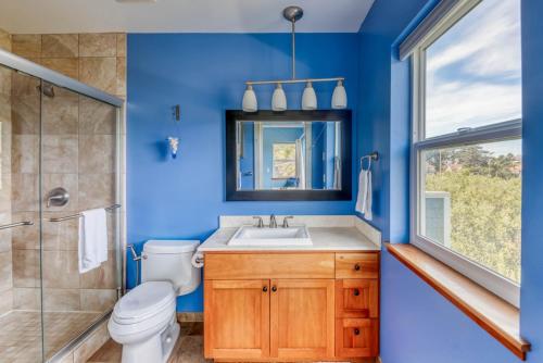 a blue bathroom with a toilet and a sink at Lakeside Haven in Rockaway Beach