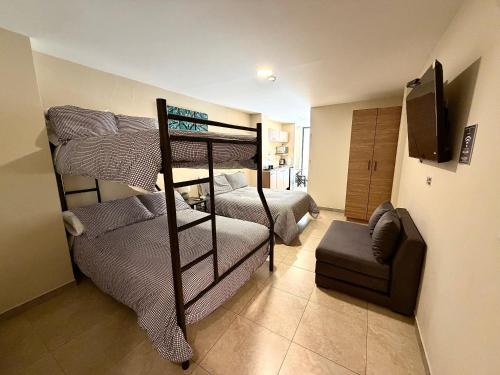 a room with two bunk beds and a chair at Suitesecu Rentals Cuenca in Cuenca