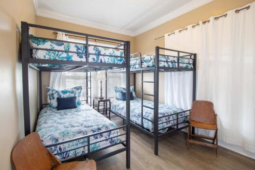 a bedroom with two bunk beds and a chair at Sand N Surf in Folly Beach