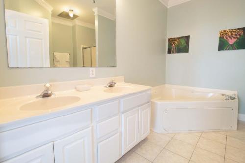 a bathroom with a sink and a toilet and a mirror at Sand N Surf in Folly Beach