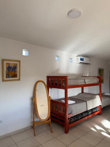 a bedroom with two bunk beds and a mirror at Alojamiento Caroya in Colonia Caroya