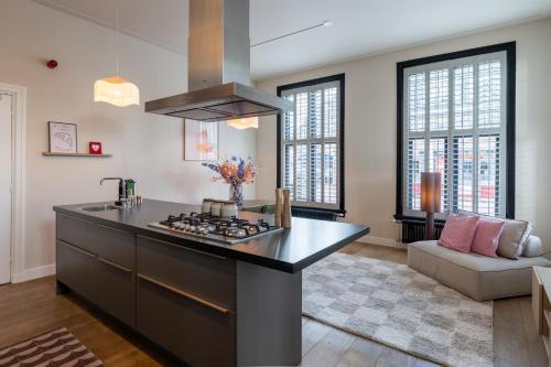a kitchen with a large island with a stove at Luxe appartement in het hart van Castricum in Castricum