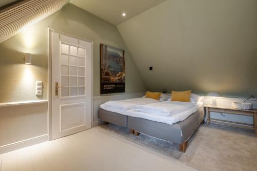 a bedroom with a bed and a white door at Inselidyll Alter Friesenhof in Süderende