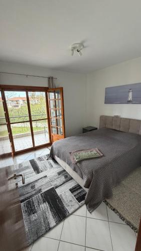 a bedroom with a bed and a large window at Halkidiki in Skala Fourkas