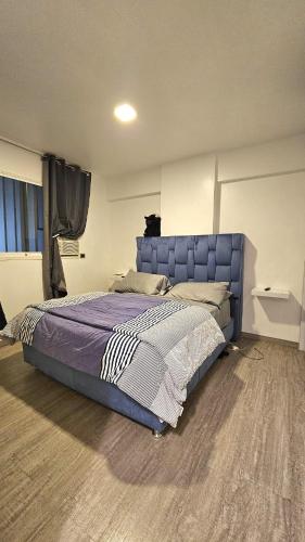 a bedroom with a large bed with a blue headboard at Comodidades, modernidad, céntrico in Caracas